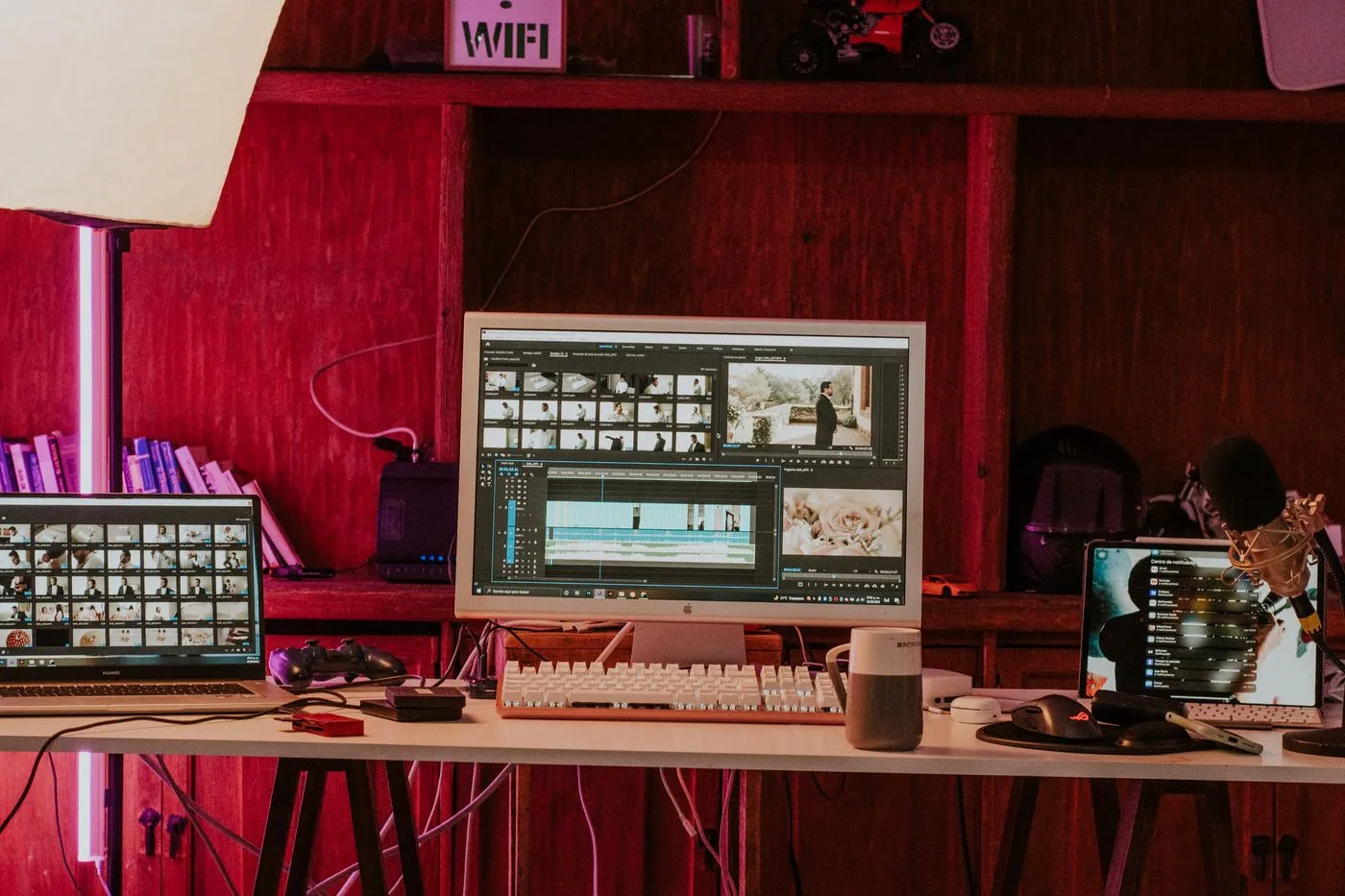 A home editing desk with a monitor, keyboard and microphone