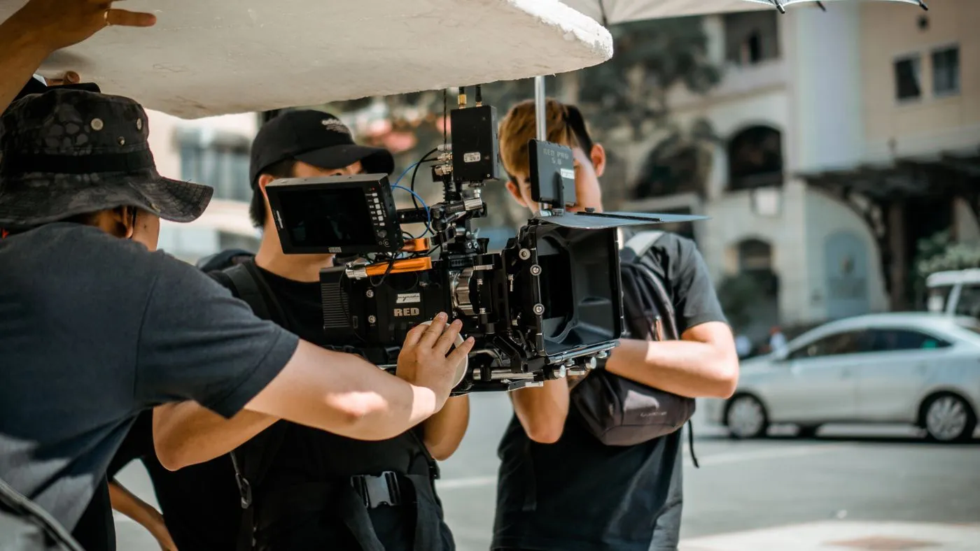 A film crew operating a RED camera on a city street