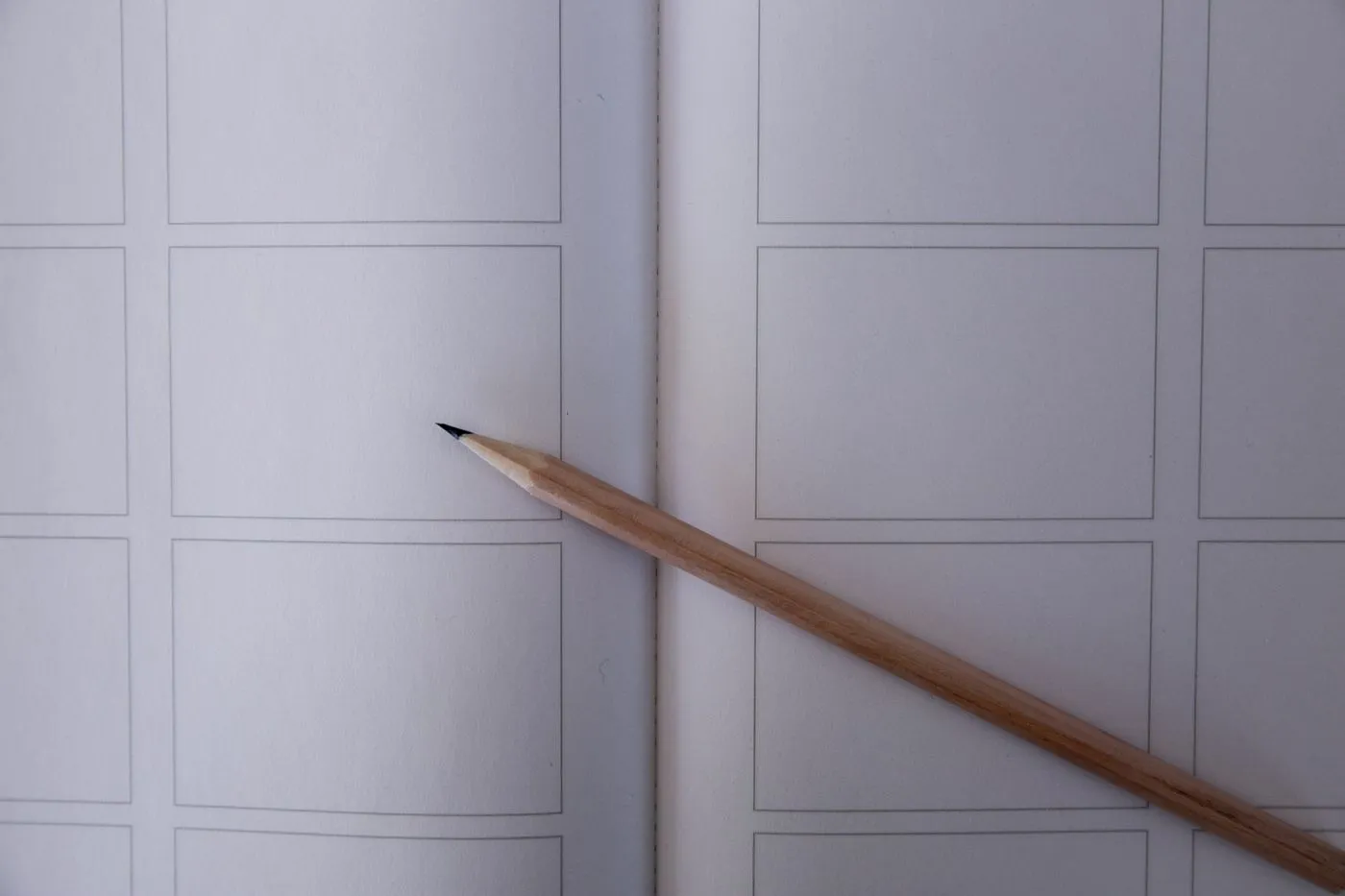 A pencil resting on a blank sheet of paper, ready for sketching